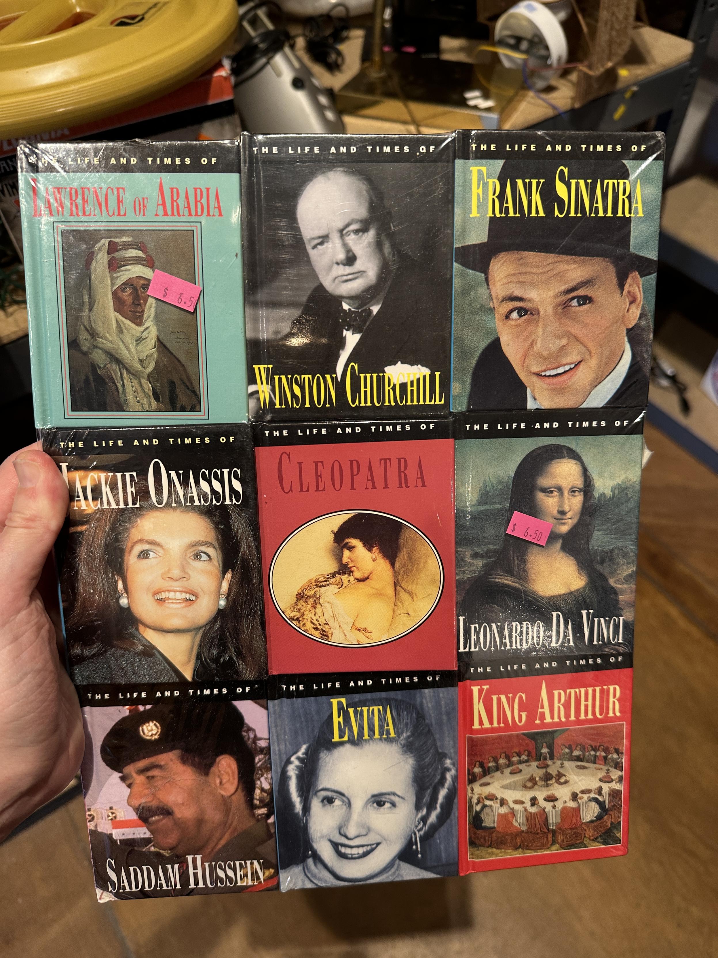 A set of nine short biographies of lawrence of arabia, churchill, sinatra, jackie o, cleopatra, leonardo da vinci, saddam, evita peron, and king arthur 