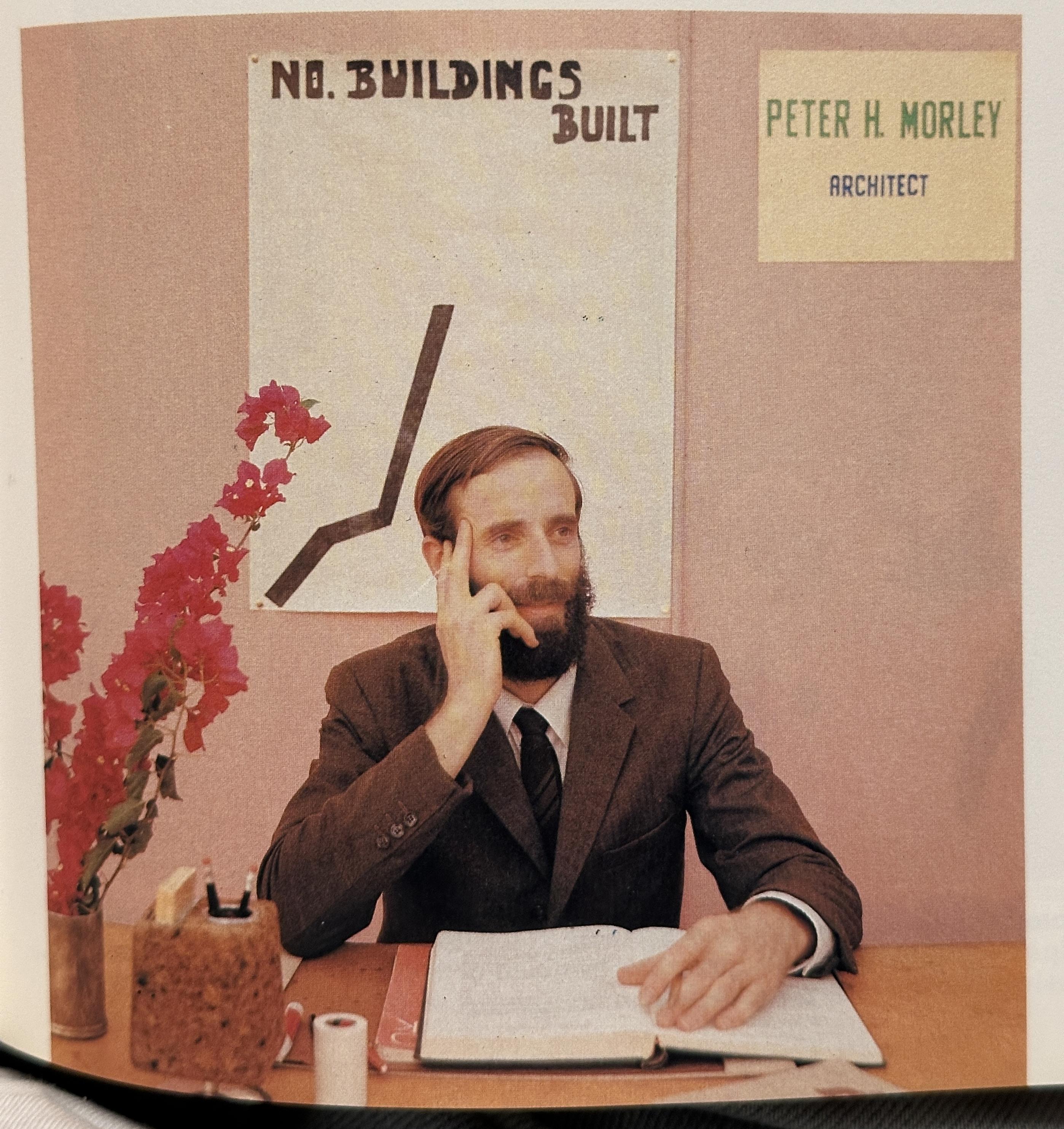 A guy looking satisfied in front of a childish graph that says “no. buildings built” and a line going up. His name is peter h morley, architect