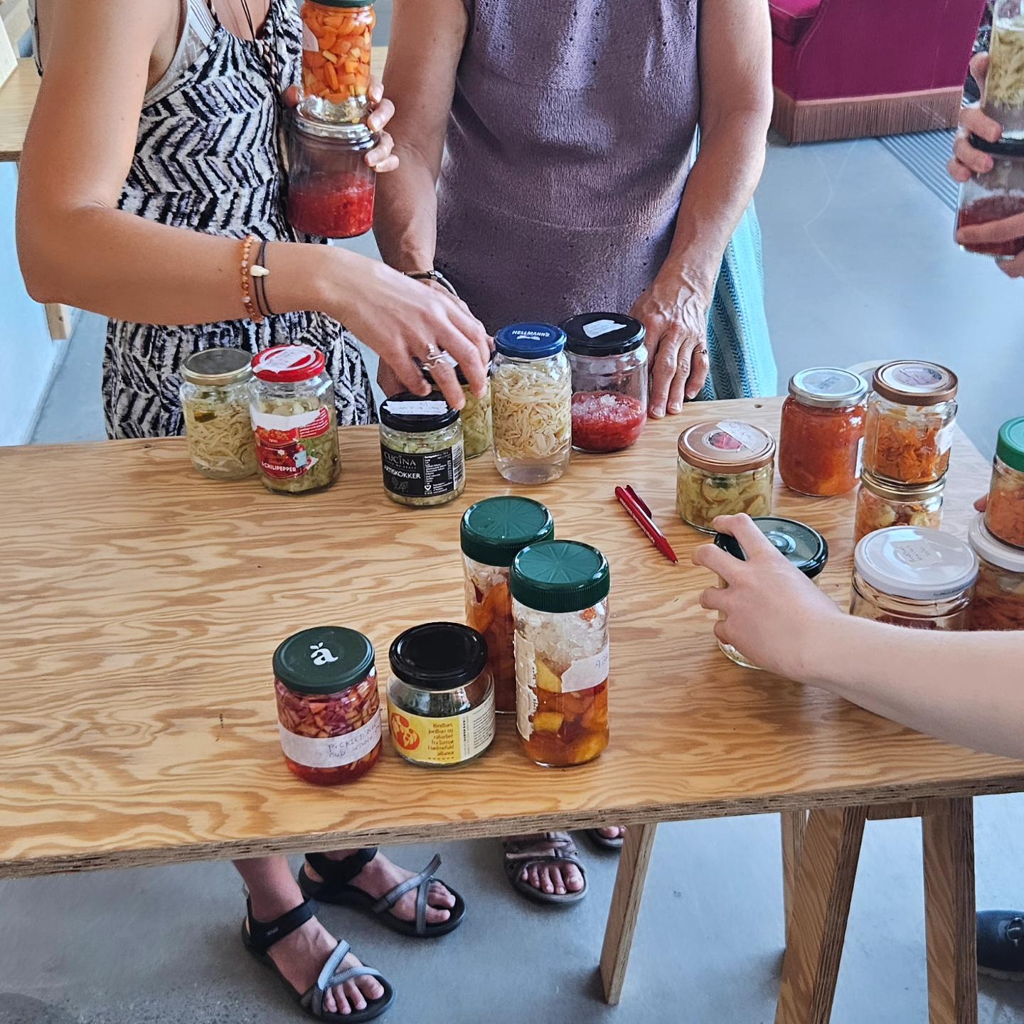 People picking up reused jars full of colourful food