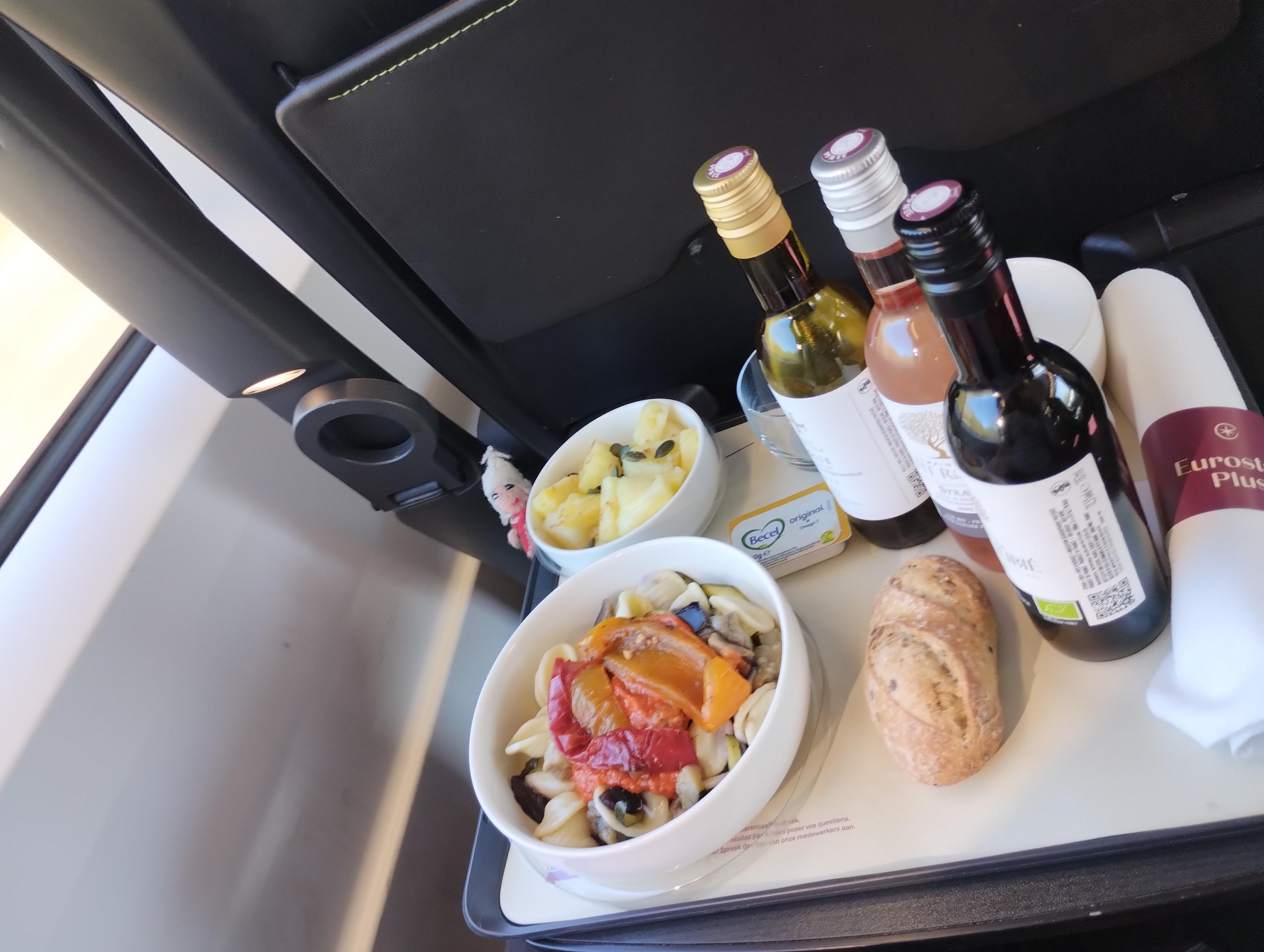 Eurostar Plus vegan meal tray offering with pasta salad and peppers, some bread, and three bottles of wine.