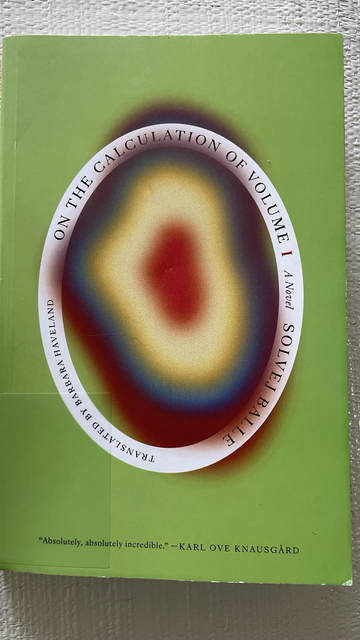 Green book cover with a blurry multicolored oval in the center
