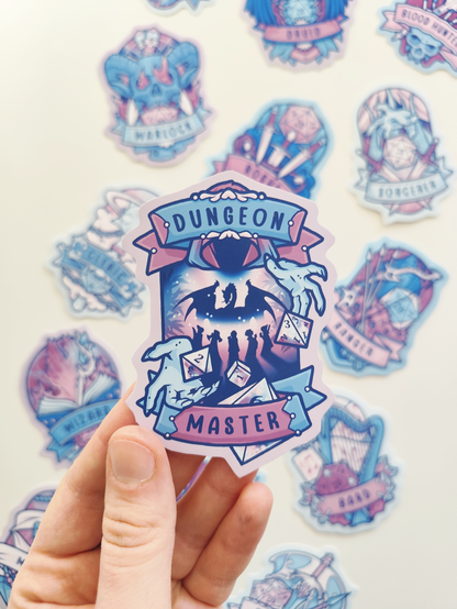 hand holding up a sticker of the DnD master, showing a hooded figure throwing dice over a group of travellers