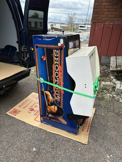 Sharkey's Shootout pinball machine in transportation mode outside next to a van.