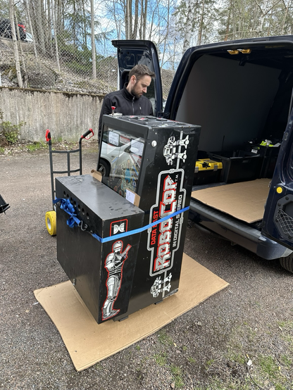 Robocop pinball machine, folded up next to a van.