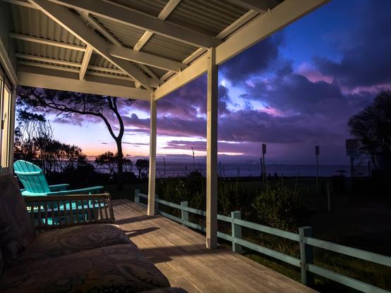 The porch, ocean, and moon at dusk.