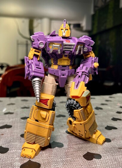 Impactor with panel lined shins, feet and weapons standing on a table of at the SF book store cafe