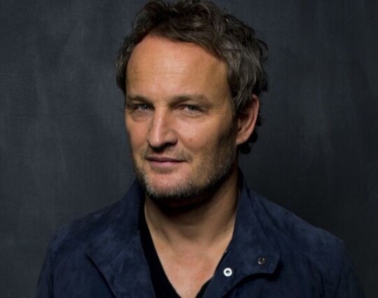Some in-studio promo pic for magazines or whatsuch. Greyish background, a velvety suede looking jacket in blue, a black V-neck shirt underneath that.

He has a glint of something in his eyes + in the corner of the mouth here. Not entirely a full smile nor mischief but there's something captivating somewhere in all that.