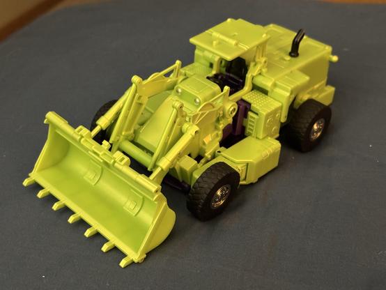 X-Transbots Ground Bite, a Masterpiece-sized version of Transformers Constructicon Scrapper, in alt mode: a bright green front loader construction vehicle. 