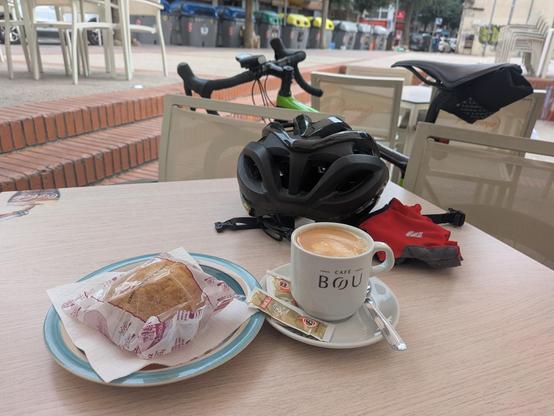coffee and pastry on the table with cycling helmet and gloves