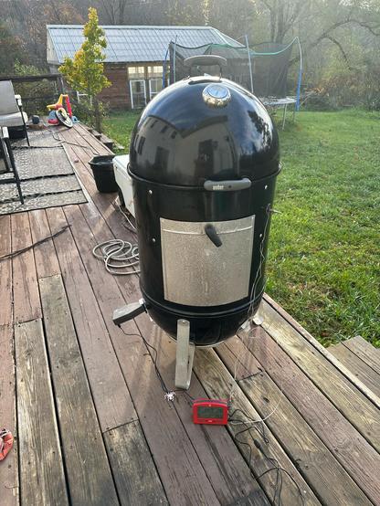 Weber smoky mountain smoker churning away with sunrise behind it