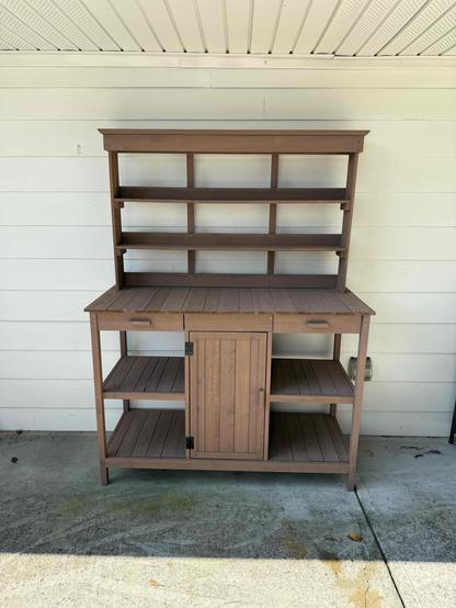 Outside potting table - made of red cedar work area approximately 66” x 20” Storage shelves underneath work area with center door two narrow shelves above the back edge.