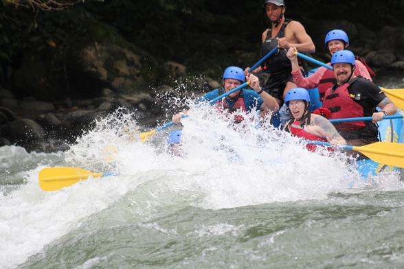 ^ tourists plus guide in raft going through rapids on Pacuare River in Costa Rica