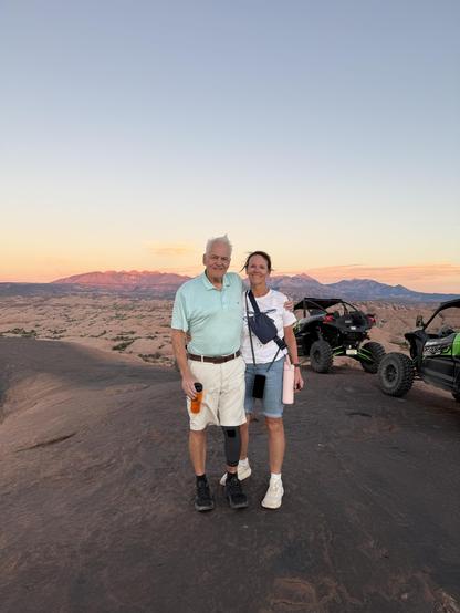 Collette and I at sunset in an area adjacent to but not in the park at sunset

Colorful sunset paints the mountains in the background 

4 wheel drive ATVs visible on the right side of the frame. That’s how we got here, sometimes climbing and descending inclines in these machines that seem like they shouldn’t be possible.