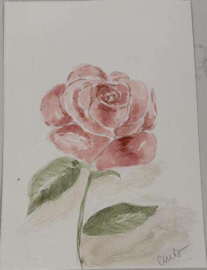 Single pink rose on a short stem with a couple of green leaves. Obviously not mass produced. The style suggests possibly water color or some kind of stamp or pressing (though not 3-d).