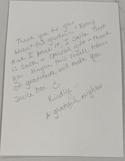 Hand written note that reads:
Thank you for your beautiful garden! Every time I pass it, I smile. That is such a special gift - thank you. Maybe this small token of gratitude will make you smile too. (hand drawn smily face)

Kindly - 
A grateful neighbor