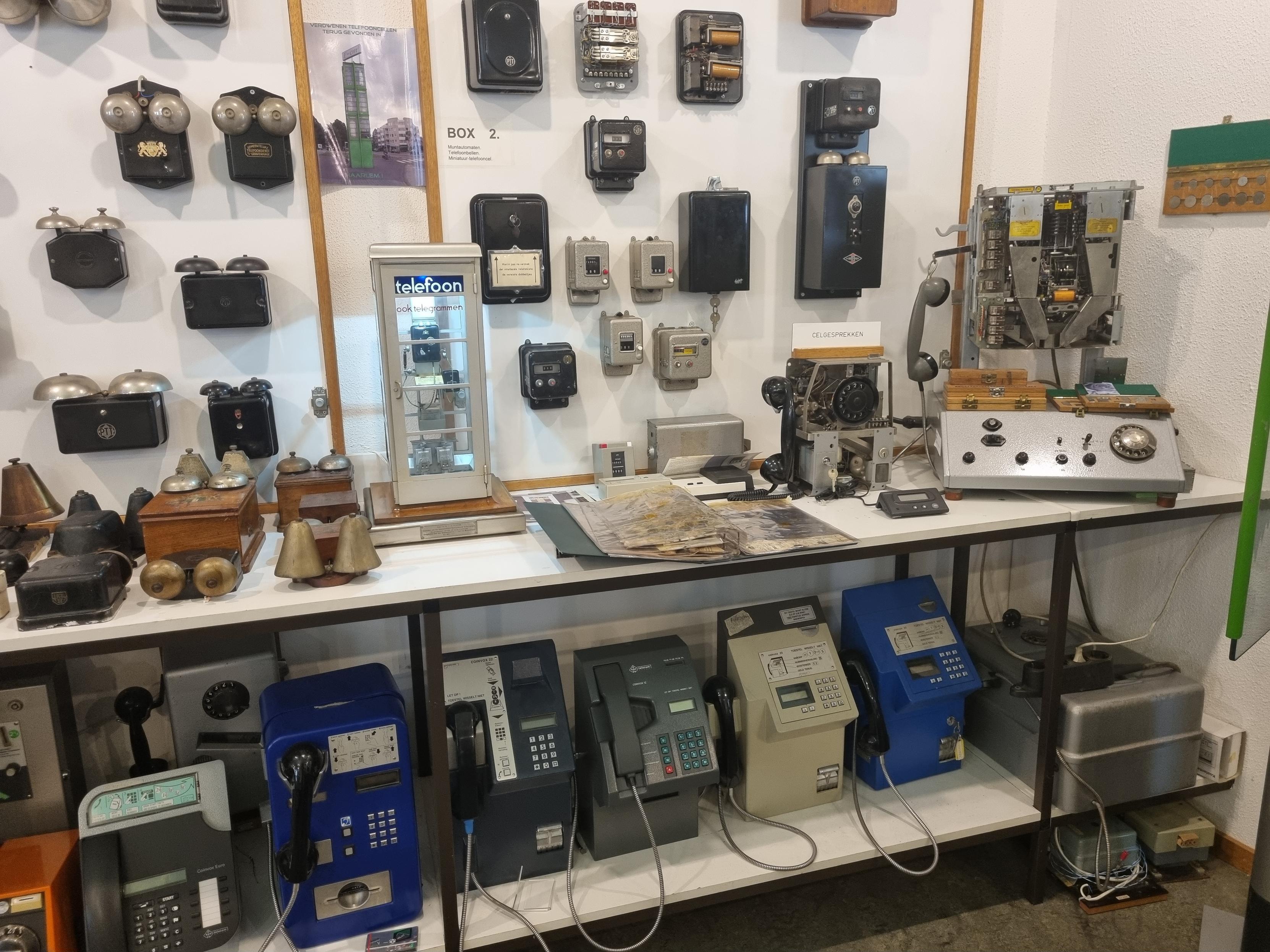 Museum exhibits relating to telephone bells, and payphones. Many examples of each are shown, including a payphone with the casing removed so the mechanisms are visible 