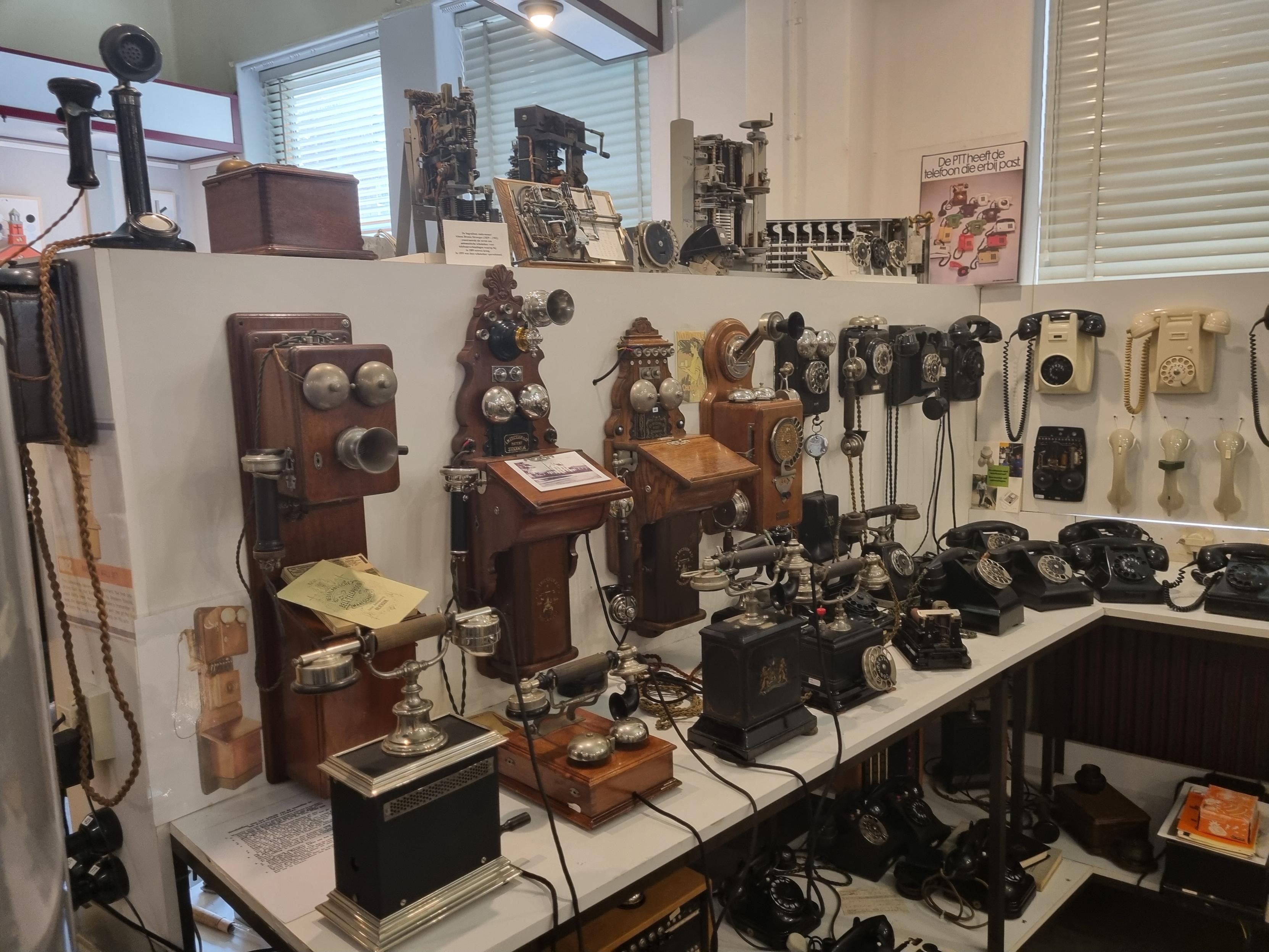 Many antique telephones (mostly with wood or bakelite cases) on display. 