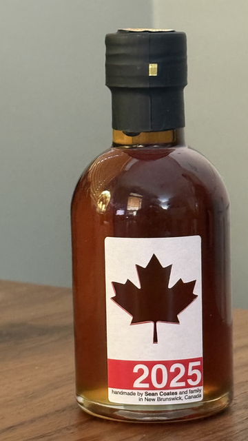 A small 100ml bottle marked 2025 with a maple leaf.