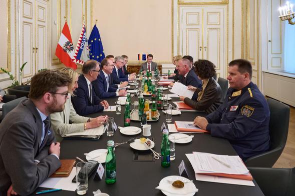 Foto: BMI / Karl Schober. Der deutsche Innenminister Dobrindt und der österreichische Innenminister Karner beraten. Neben ihnen Mitarbeiter ihrer jeweiligen Häuser.