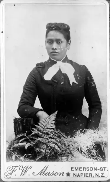 A visiting card by F W Mason with a photo of Meri Te Tai Mangakāhia. She is a Māori woman in a dark fitted jacket with a pale bow at her neck. Her hair is in a plaited bun. 

Image credit: Mason, Frederick W., photographer. [Copy of Portrait of Meri Te Tai Mangakāhia]. Auckland War Memorial Museum Tamaki Paenga Hira. PH-NEG-C5101.
