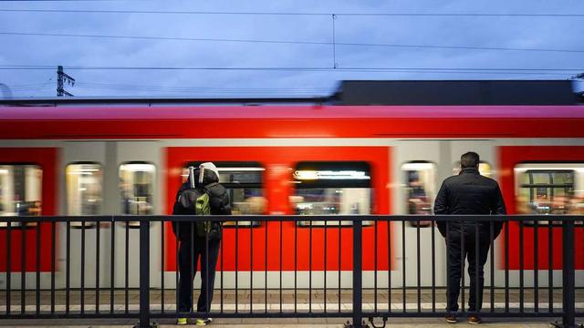 Menschen warten am Pasinger Bahnhof, während ein Zug abfährt. (Symbolbild)