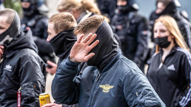 Die Neonazi-Gruppe "Jung und Stark" demonstriert in der Innenstadt von Essen. Ultra Rechte, in Schwarz gekleidet und mit szenetypischen Kleidungstücken. Ein Mann vorne verdeckt sein Gesicht.
