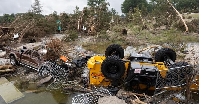 Trucks are tilted over at Louise Hays Park in Kerrville due to heavy rainfalls that caused flooding along Guadalupe River on Sunday, July 6, 2025. Law Enforcement workers and volunteers are in the work of clearing up debris from the flooding.