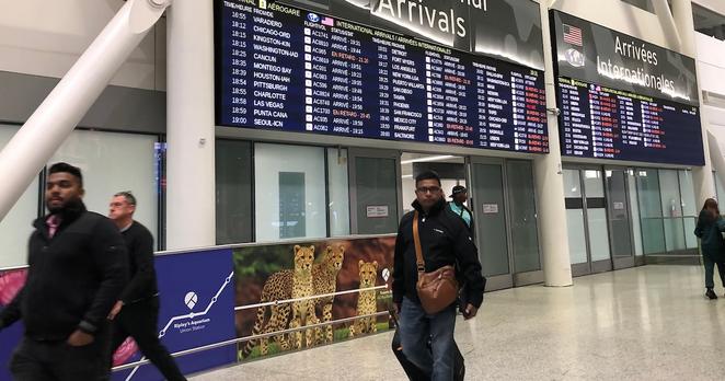 Passengers walk through the international arrivals doors at Pearson International Airport in Toronto, Wednesday, Nov.16, 2022. THE CANADIAN PRESS IMAGES/Richard Buchan