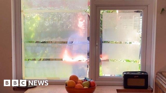 Yoghurt on a window with a man outside the window
