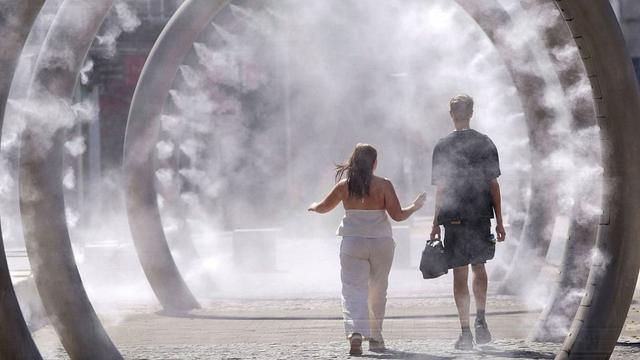 A couple walk through a cooling water feature as the third heatwave of the summer hits the UK, in Dover, 11 July 2025. | Copyright Gareth Fuller/PA via AP