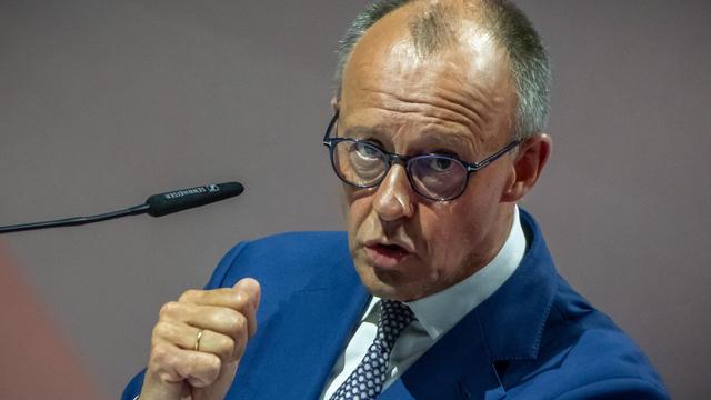 Merz spricht in ein Mikrofon und gestikuliert dabei mit der rechten Faust.