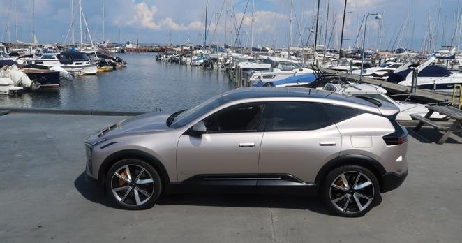Polestar 3 steht an einem Hafen. Im Hintergrund ankern Segelboote.