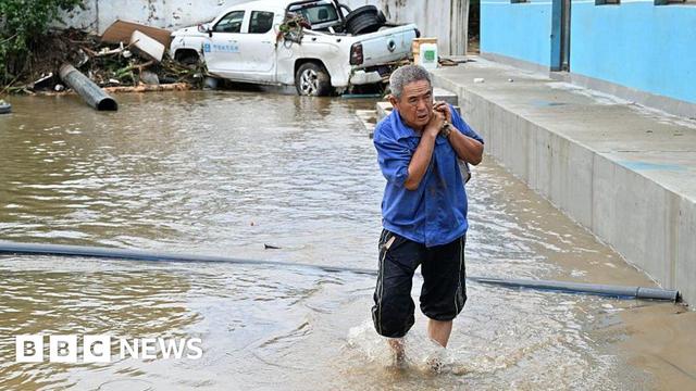 A man salvages items as floods hit an area in Miyun district, northern Beijing on July 29, 2025.