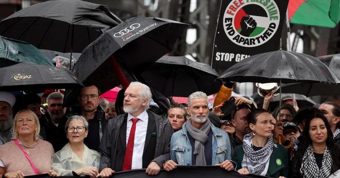 Julian Assange (3e à gauche, avec une cravate rouge), traverse avec d’autres manifestants propalestiniens le pont du port de Sydney, le 3 août 2025.