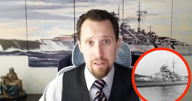EJ Antoni in front of a mural reportedly showing The German Battleship Bismarck in 1940 with an inset image of the Bismarck