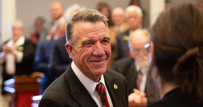 A man in a suit smiles 