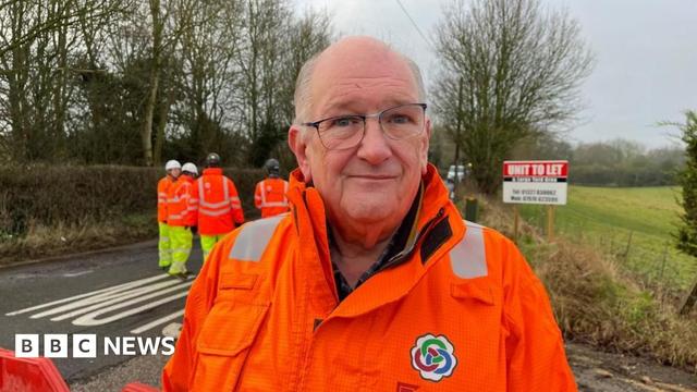 Councillor Phil Larratt in an orange high-vis jacket standing outside