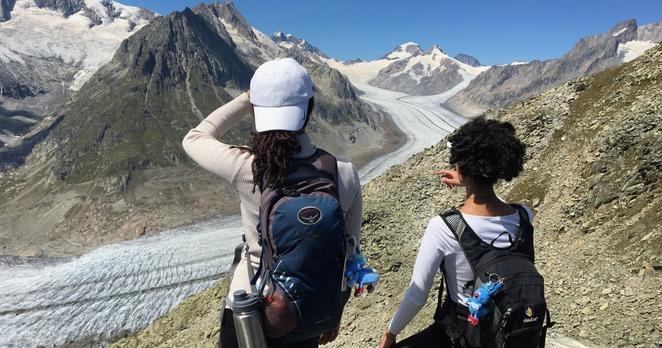 Zwei junge Frauen stehen vor dem Aletschgletscher im Sommer. Zwei junge Frauen stehen vor dem Aletschgletscher im Sommer.