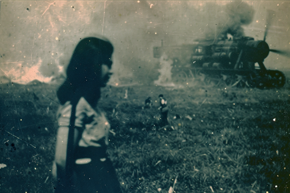 A young partisan after a successful attack on a giant air tractor, now burning