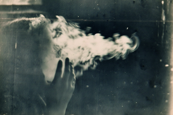 A smoke form emanates from the face of a female medium