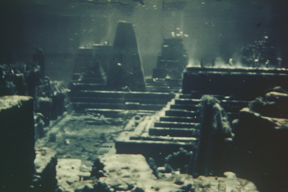 The ruins of an ancient city at the bottom of the ocean, with stepped buildings, plazas and towers