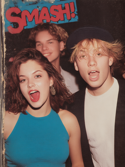 The image shows three young people in a casual setting. In the foreground, there is a young woman with shoulder-length brown hair, wearing a bright blue sleeveless top and large earrings. She has her mouth open as if speaking or reacting. Beside her, a young man with blonde hair wears a black cap and a white t-shirt under a dark jacket. He also has his mouth open. Behind them, a third person, another young man with curly hair, smiles. The backdrop is dark with a poster at the top displaying the word "SMASH!" in large, red, bold lettering set against a blue background.