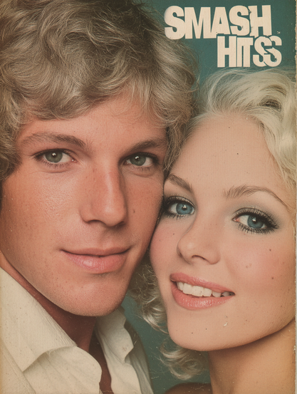 The image is a close-up portrait of a man and a woman, both with light-colored hair and bright eyes. They are positioned closely together, with the man on the left and the woman on the right. The man has curly, light brown hair and is wearing a white collared shirt. He has a relaxed expression on his face. The woman has blonde hair styled in soft waves, with makeup accentuating her eyes and lips. She has a bright smile with visible teeth. In the top right corner, the bold text "SMASH HITSS" is displayed in white against a solid teal background.