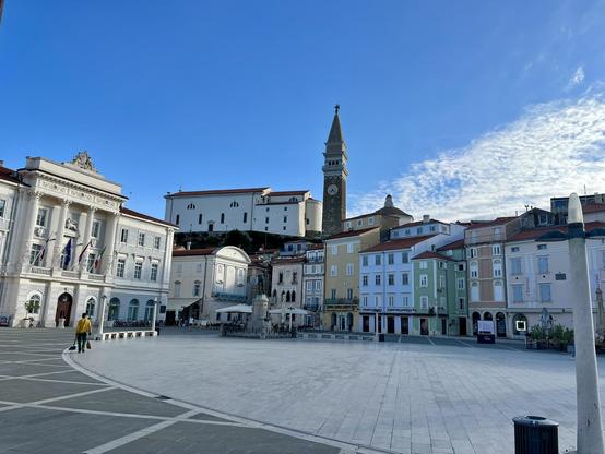 This is the main old city sqaure of the pitoresque town or Piran, at the southernmost end of Slovenia. The square is surrounded by historical classicistic buildings. You see the campanile of the church behind those buildings.