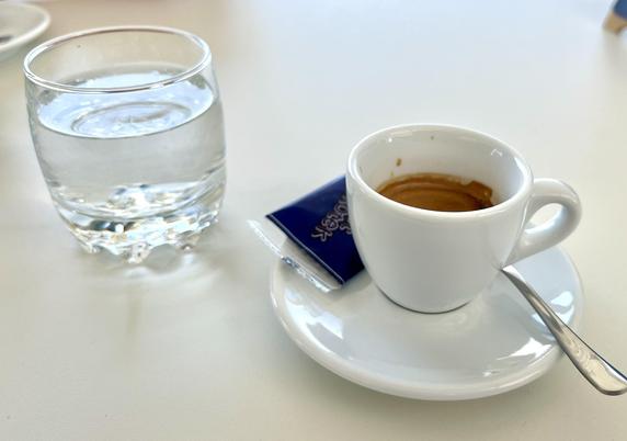 Espresso with a glass of water on a white table
