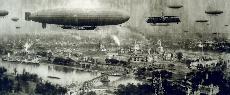 Airships and an early aeroplane fly over a city with a bridge and river.