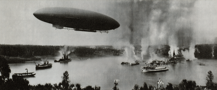 A vintage image of an airship over a river with steamboats and rising smoke.