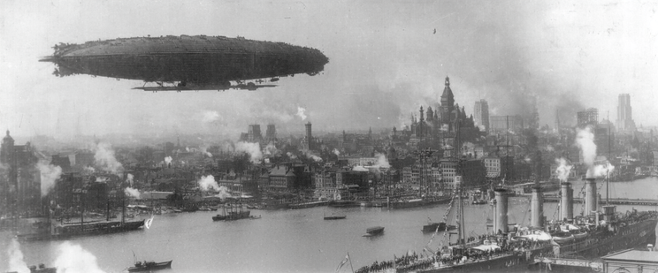 A large airship flies over a bustling urban waterfront with a docked ship and smoky chimneys.