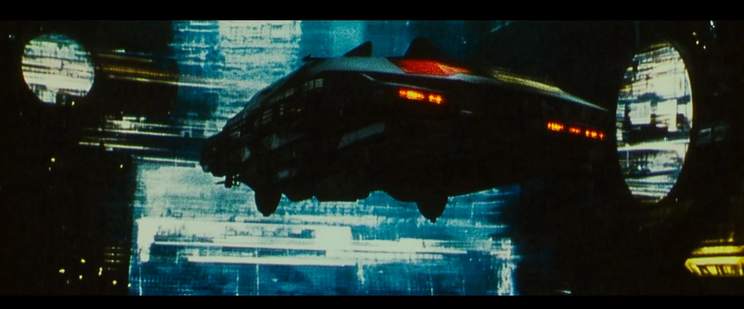 A futuristic flying vehicle with red lights hovers in front of a digitally rendered cityscape with blue and black geometric patterns.