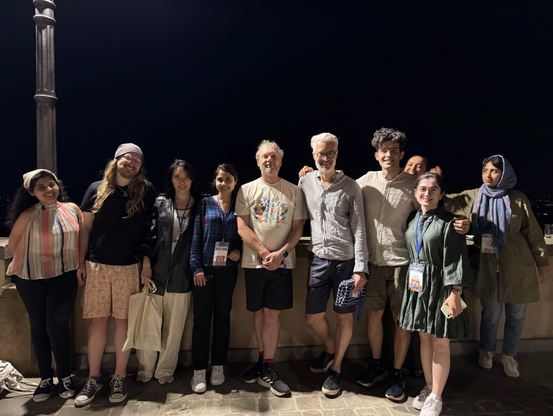 The teams from KIT AIFB and FIZ Karlsruhe meeting on the main village sqare of BErtinoro during ISWS 2025, nichttime. People are standing next to each other.